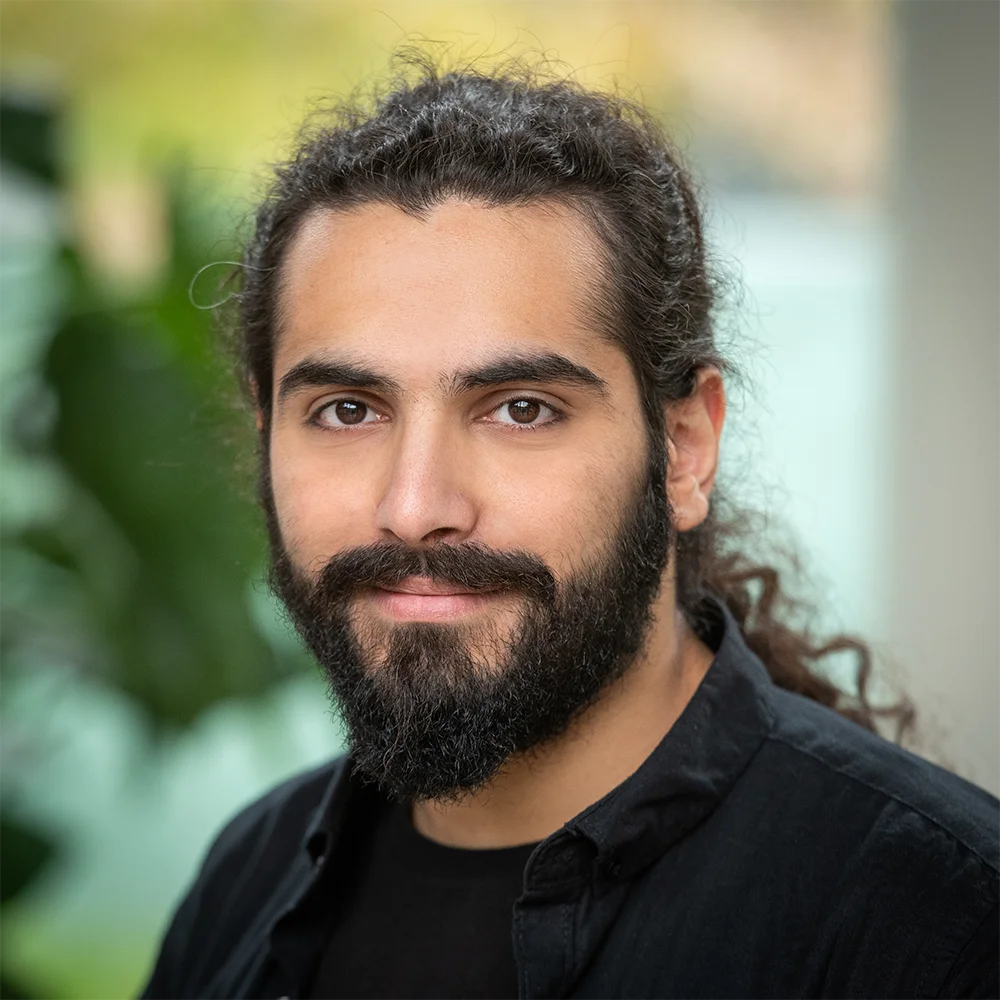 Webdeveloper Mehsen achter zijn scherm met code en DevOps-tools