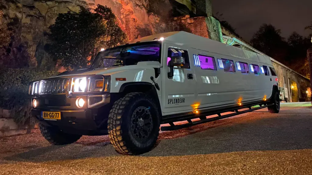 Hummer H2-limousine van Splendeur in de avond bij een verlichte rotswand