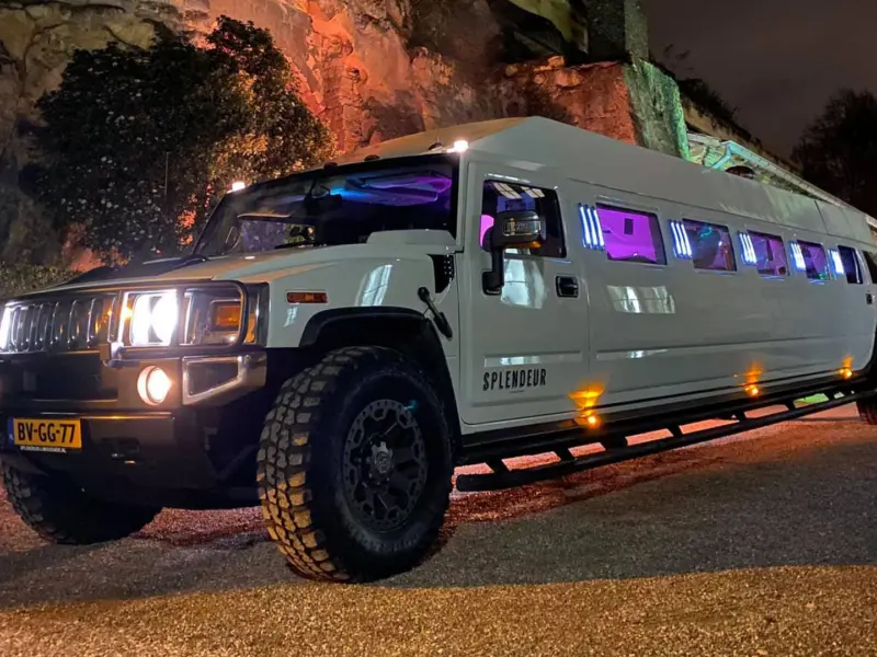 Hummer H2-limousine van Splendeur in de avond bij een verlichte rotswand