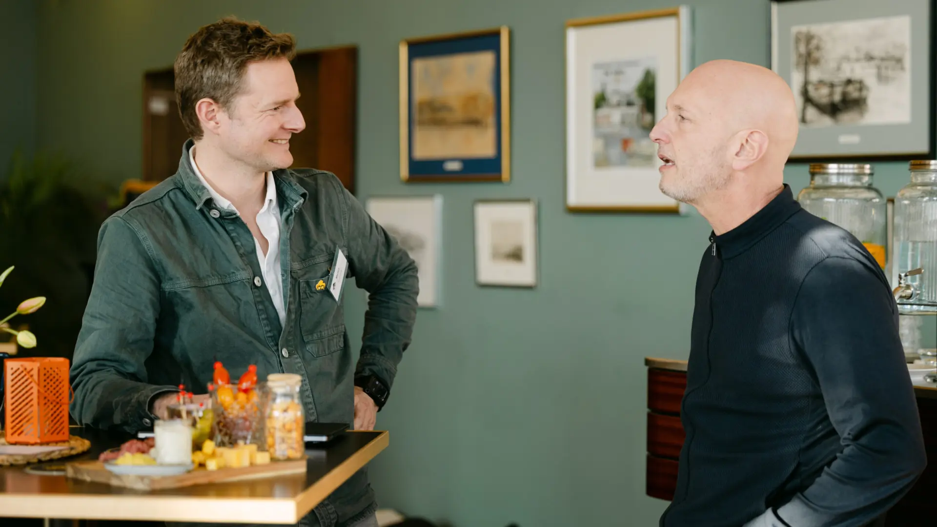 Twee mannen in gesprek bij een statafel op het kantoor van Tool2Match