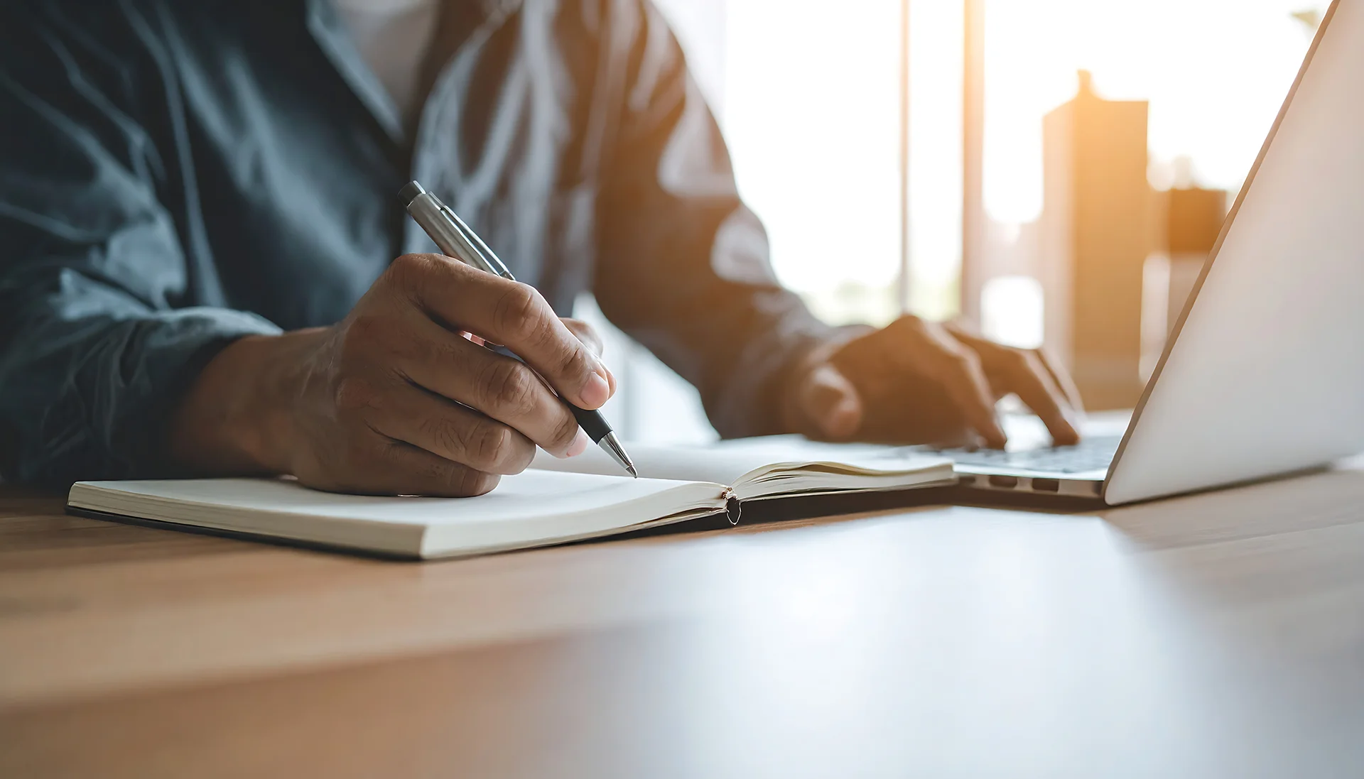 Aantekeningen maken naast een laptop bij het opstellen van een offerte